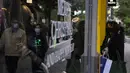 Seorang wanita yang mengenakan masker untuk mencegah penyebaran COVID-19 menunggu di luar sebuah toko di Athena, Yunani (27/12/2021). Pembatasan baru mencakup mandat memakai masker di luar ruangan dan semua area publik. (AP Photo/Thanassis Stavrakis)