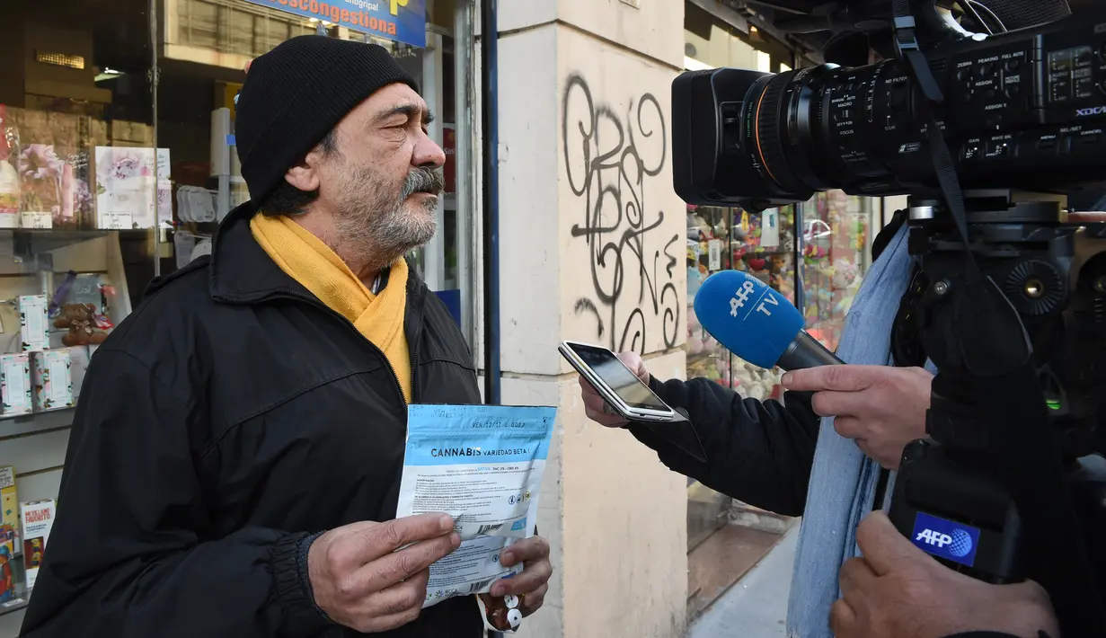 Seorang pria pembeli ganja kemasan memberi keterangan kepada awak media di di Montevideo, Uruguay (19/7). (AFP Photo/Miguel Rojo)