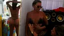 Pemilik spa, Erika memasangkan selotip yang berbentuk bikini ke pelanggannya sebelum berjemur di Rio de Janeiro, Brasil (22/11). Yang unik dari spa ini adalah, bikini dibuat dari selotip atau pita perekat yang ditempel ditubuh. (Reuters/Pilar Olivares)
