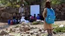 Seorang anak melihat teman-temanya mengikuti kelas terbuka di desa al-Kashar Yaman barat daya, provinsi Taez (16/9/2019). Dua pertiga sekolah rusak dalam serangan, 27 persen ditutup dan tujuh persen digunakan militer atau sebagai tempat perlindungan bagi para pengungsi. (AFP Photo/Ahmad Al-Basha)