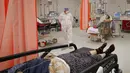 Pasien berbaring di tempat tidur di ruang gawat darurat yang berubah menjadi unit COVID-19 karena tingginya jumlah kasus, di rumah sakit Bagdasar-Arseni, Bucharest, Selasa (12/10/2021). Rumania pada Selasa melaporkan hampir 17.000 Infeksi baru COVID-19 dan 442 kematian. (AP Photo/Andreea Alexandru)