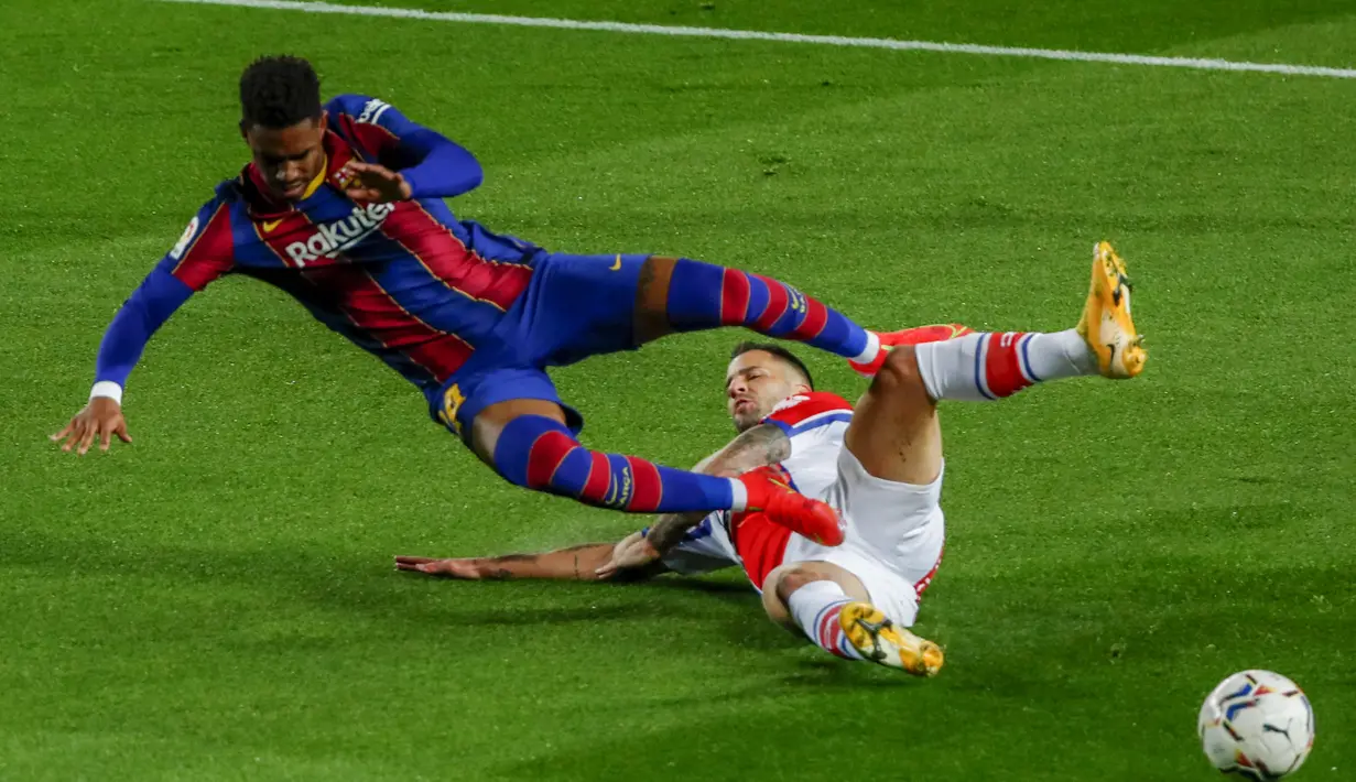 Bek Barcelona,  Junior Firpo saat dilanggar gelandang Deportivo Alaves, Edgar Mendez  pada pertandinga lanjutan La Liga Spanyol di stadion Camp Nou, Spanyol, Minggu (14/2/2021). Sementara, Alaves di peringkat ke-16 dengan 22 angka. (AP Photo/Joan Monfort)