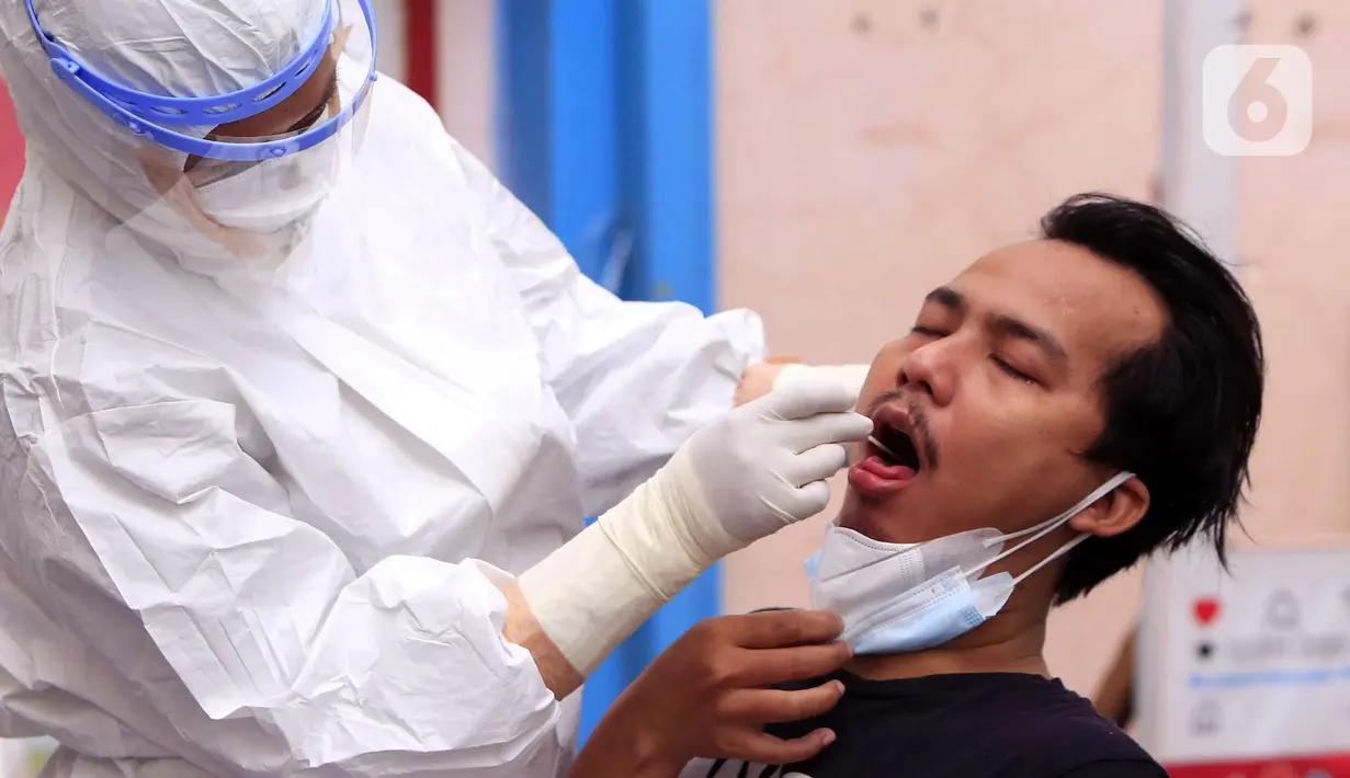 Tenaga kesehatan melakukan tes PCR COVID-19 kepada warga di Puskesmas Cipadu, Tangerang, Banten, Selasa (22/2/2022). Kasus COVID-19 di Jawa-Bali perlahan-lahan menurun. (Liputan6.com/Angga Yuniar)