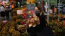 Seorang wanita membeli bunga untuk merayakan Tahun Baru Imlek di Hong Kong, Rabu (19/1/2022). Tahun Baru Imlek China jatuh pada 1 Februari 2022. (AP Photo/Kin Cheung)