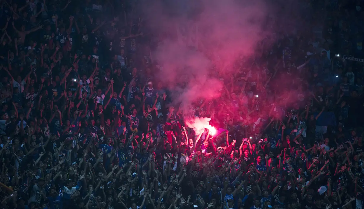 Bobotoh meluapkan ekspresi kegembiraan dengan menyalakan suar usai Persib mengalahkan PS Polri 3-1. (Bola.com/Vitalis Yogi Trisna)