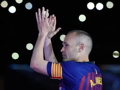 Andres Iniesta memberikan applause kepada suporter pada laga terakhirnya bersama Bracelona di pertandingan pekan ke-38 La Liga melawan Real Sociedad, Minggu (20/5). Iniesta resmi meninggalkan Barcelona setelah 22 tahun berkarier di sana. (AFP/LLUIS GENE)