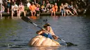 Emma Gray, dari Tualatin, mendayung labu raksasa menuju garis finish dalam event West Coast Giant Pumpkin Regatta di Tualatin, Oregon, Amerika Serikat pada 16 Oktober 2022. Labu raksasa yang sudah dilubangi tersebut dijadikan kano untuk lomba mendayung. (Photo by Wesley Lapointe / AFP)