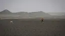 Seorang peserta menyusuri lahan bebatuan saat mengikuti lomba lari Marathon des Sables ke-34 tahap kedua di Gurun Sahara, Maroko, Senin (8/4). Selain harus berlari dalam jarak yang sangat jauh, peserta juga harus mengatasi iklim ekstrem Sahara. (JEAN-PHILIPPE KSIAZEK/AFP)