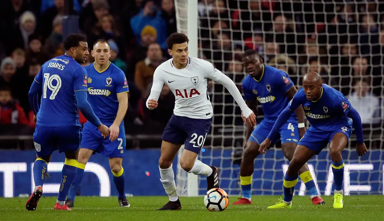 Pemain Tottenham Hotspur, Dele Alli menggiring bola dengan kawalan pemain Wimbledon pada pertandingan putaran ketiga FA Cup di Stadion Wembley, Minggu (7/1). Tottenham Hotspur menyarangkan tiga gol tanpa balas ke gawang Wimbledon. (AP/Tim Ireland)