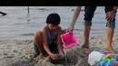 Seorang bocah sedang bermain pasir saat Lebaran di pantai Ancol, Jakarta, Senin (28/7/2014) (Liputan6.com/Andrian M Tunay)