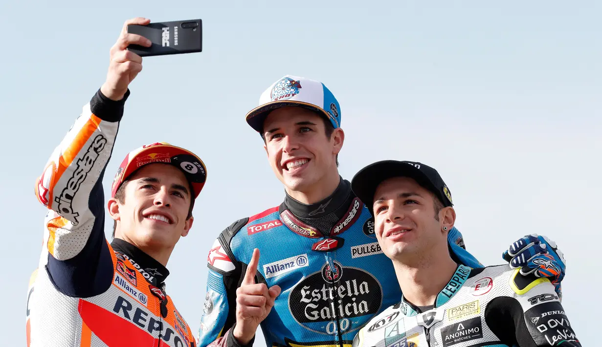 Pembalap MotoGP Marc Marquez (kiri) bersama pembalap Moto2 Alex Marquez (tengah) dan pembalap Moto3 Lorenzo Dalla Porta (kanan) berswafoto di depan Valencia Motorcycle Grand Prix, Spanyol, Minggu (17/11/2019). Ketiganya sukses merebut gelar juara dunia tahun 2019. (AP Photo/Alberto Saiz)