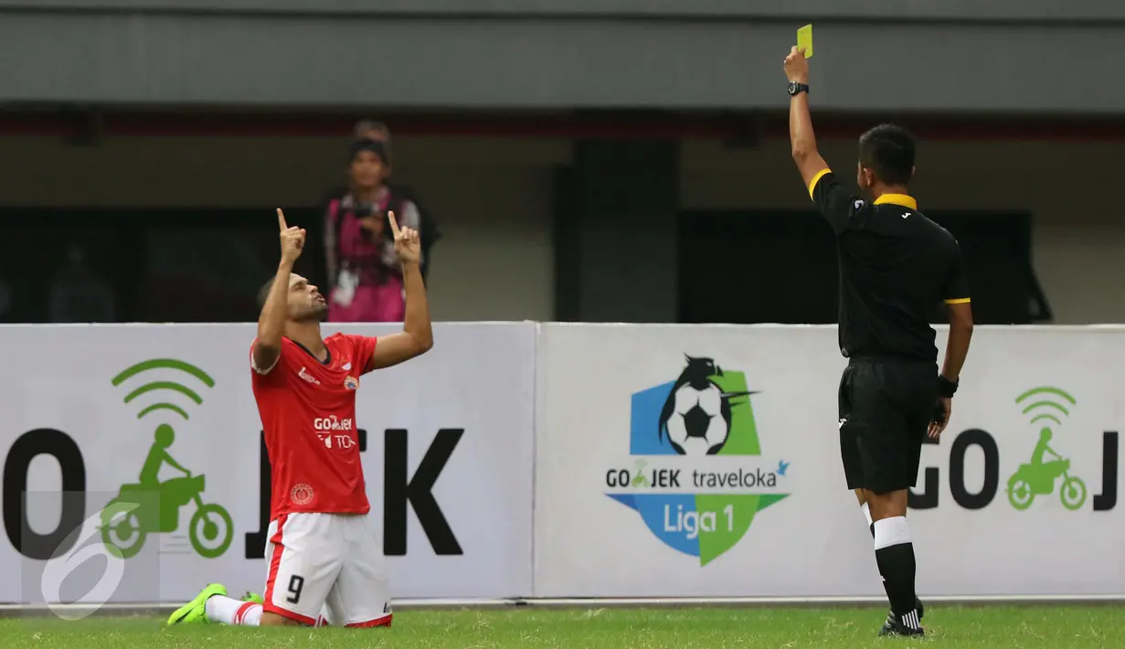 Wasit memberikan kartu kuning ke pemain Pemain Persija Jakarta saat melawan Barito Putera dalam pertadingan Liga 1 di Stadion Patriot, Bekasi (22/4). (Liputan6.com/Gempur M. Surya)