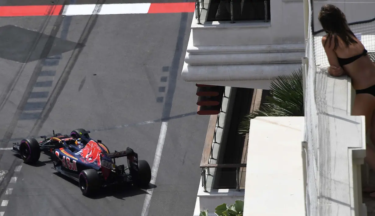 Seorang turis menyaksikan pebalap Toro Rosso, Carlos Sainz Jr, yang melintas saat latihan bebas F1 GP Monako, (26/5/2016). (AFP/Pascal Guyot)