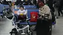 Seorang anak makan roti sambil menunggu kereta api di Stasiun Kereta Selatan di Beijing, Chinan (14/1/2022). Partai Komunis yang berkuasa khawatir fakta ini bisa menghalangi ambisi mereka untuk meningkatkan kekayaan nasional dan pengaruh global. (AP Photo/Ng Han Guan)