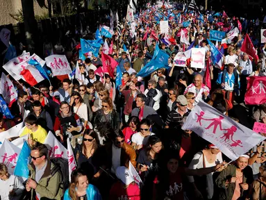 Pengunjuk rasa melakukan aksi protes dengan membawa bendera dan spanduk anti gay di Paris, Prancis, Minggu (16/10). Mereka membawa bendera yang bertuliskan "La Manif Pour Tous" dan menentang pernikahan sejenis. (Reuters/ Benoit Tessier)