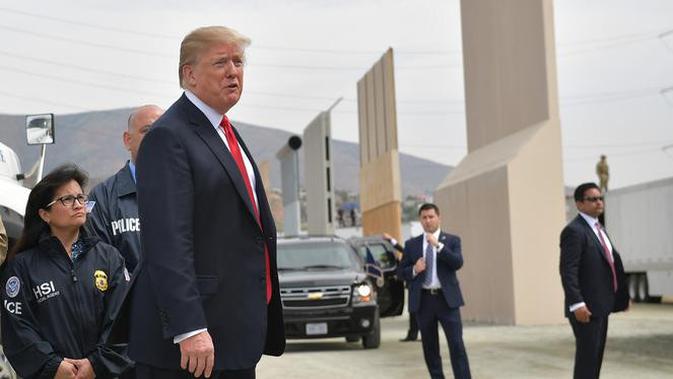 Presiden AS, Donald Trump meninjau prototipe tembok perbatasan AS dan Meksiko yang kontroversial di San Diego, Selasa (13/3). Prototipe tembok perbatasan Trump memiliki tinggi sekitar 9 meter, dengan puncak yang tebal dan bundar. (MANDEL NGAN / AFP)