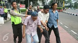 Petugas kepolisian membawa dua orang pencopet menuju Polsek Menteng dari Pospol Bundaran HI, Jakarta, Rabu (3/5). Aksi mereka di Kopaja P19 digagalkan setelah korban melawan dan mengejar hingga ke kawasan HI. (Liputan6.com/Angga Yuniar)