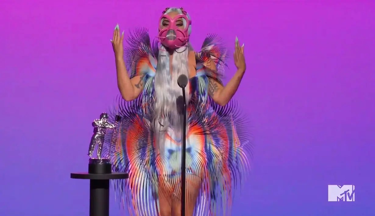 Dalam foto yang dirilis memperlihatkan Lady Gaga menerima penghargaan sebagai kolaborasi terbaik untuk "Rain on Me" dalam MTV Video Music Award (MVA) 2020 secara virtual pada Minggu (30/8/2020) waktu New York. Lady Gaga menjadi sorotan karena masker wajah yang dikenakannya. (MTV via AP)