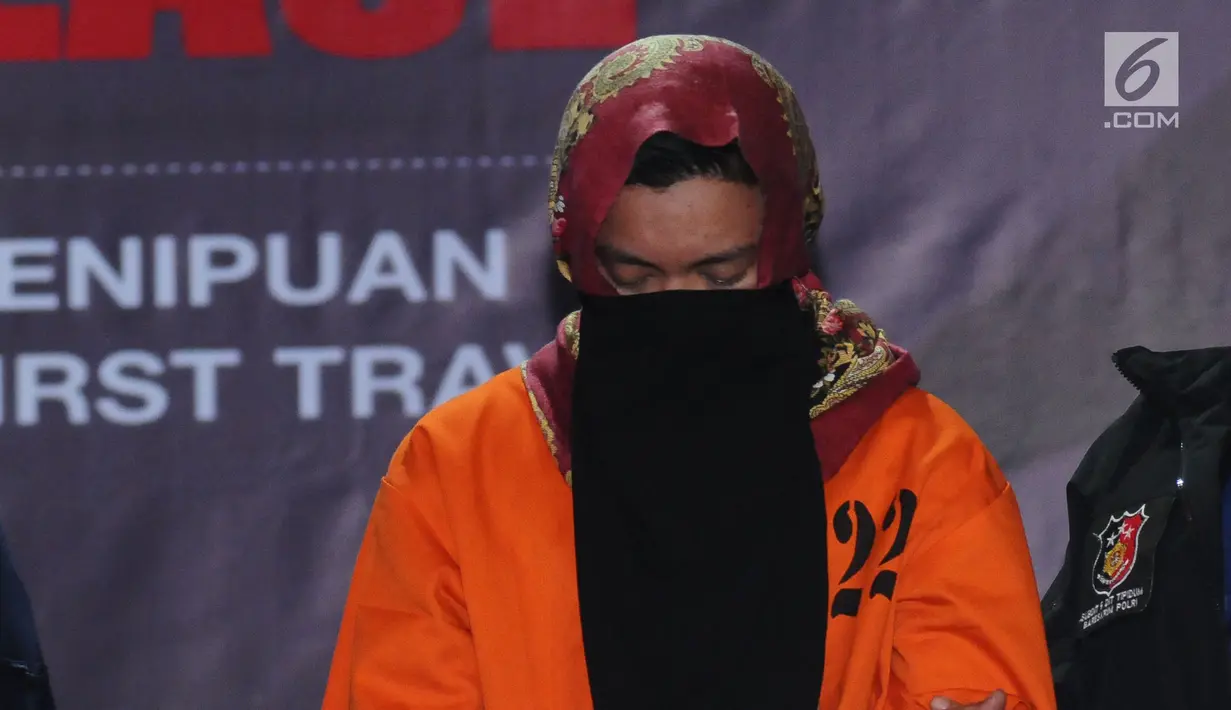 Tersangka kasus penipuan calon jemaah umroh, Kiki Hasibuan menunduk saat diperlihatkan polisi di Bareskrim Mabes Polri, Jakarta, Selasa (22/8). Hingga kini, polisi telah menetapkan tiga tersangka kasus tersebut. (Liputan6.com/Helmi Fithriansyah)