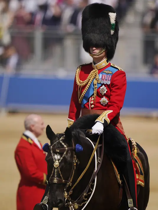 Beberapa tentara Inggris merasa kepanasan pada hari Sabtu saat mereka mengenakan tunik wol dan topi kulit beruang untuk memberi hormat kepada Pangeran William. (AP Photo/Alberto Pezzali)