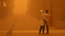 <p>Perempuan mengambil video dengan smartphone mereka di tengah badai debu parah di Kuwait City pada 23 Mei 2022. Kabut oranye tebal telah menyelimuti Kuwait pada hari Senin, menyebabkan penerbangan ke dan dari bandara internasional negara itu ditangguhkan sementara, kata regulator penerbangan sipil. (Yasser Al-Zayyat / AFP)</p>