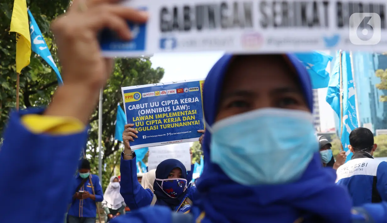 Para buruh dari berbagai aliansi membawa poster saat menggelar aksi memperingati Hari Buruh Internasional atau May Day di Jakarta, Sabtu (1/5/2021). Mereka meminta pemerintah untuk mencabut Omnibus Law dan memberlakukan upah minimum sektoral (UMSK) 2021. (Liputan6.com/Angga Yuniar)