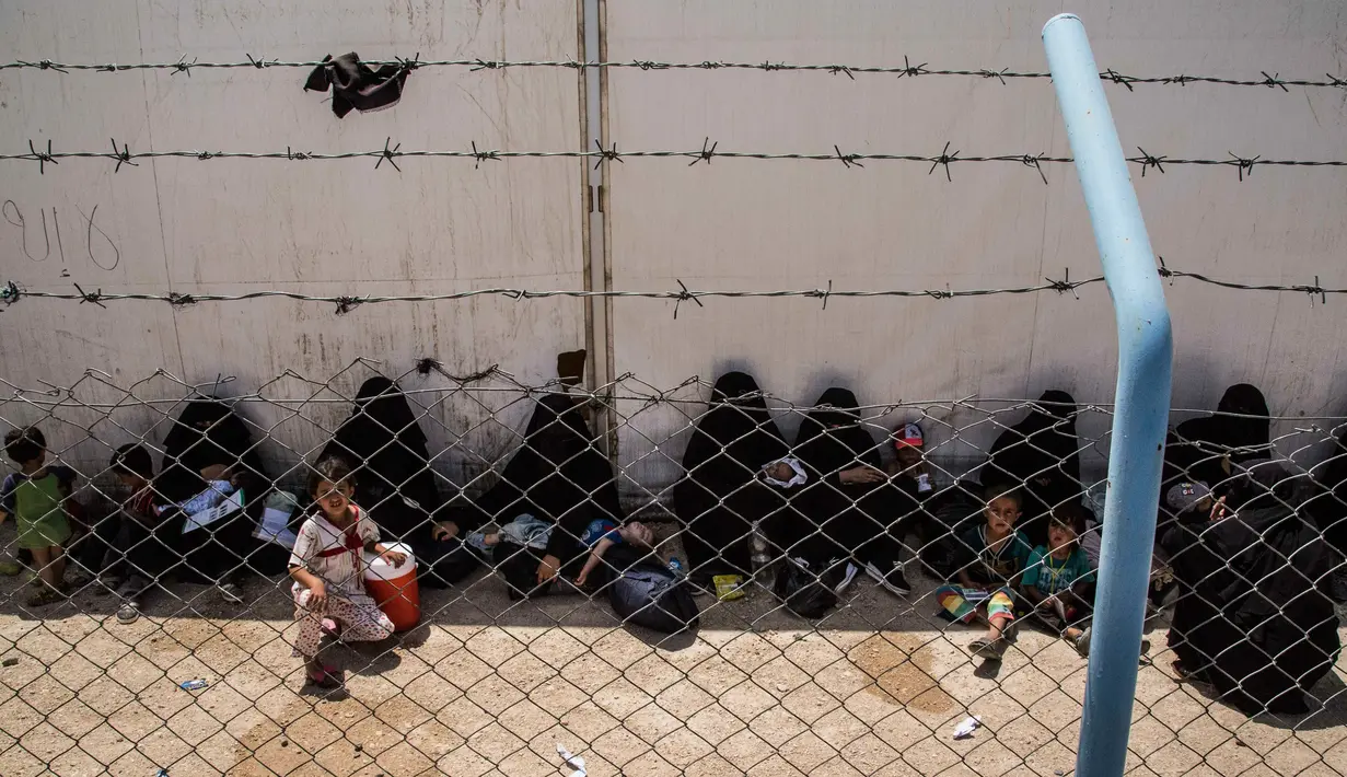 Perempuan dan anak-anak keluarga militan ISIS menunggu untuk meninggalkan kamp penampungan al-Hol di Provinsi Hasakeh, Suriah, Senin (3/6/2019). Otoritas Kurdi yang mengelola kamp tersebut membebaskan sekitar 800 perempuan dan anak-anak keluarga militan ISIS. (AP Photo/Baderkhan Ahmad)