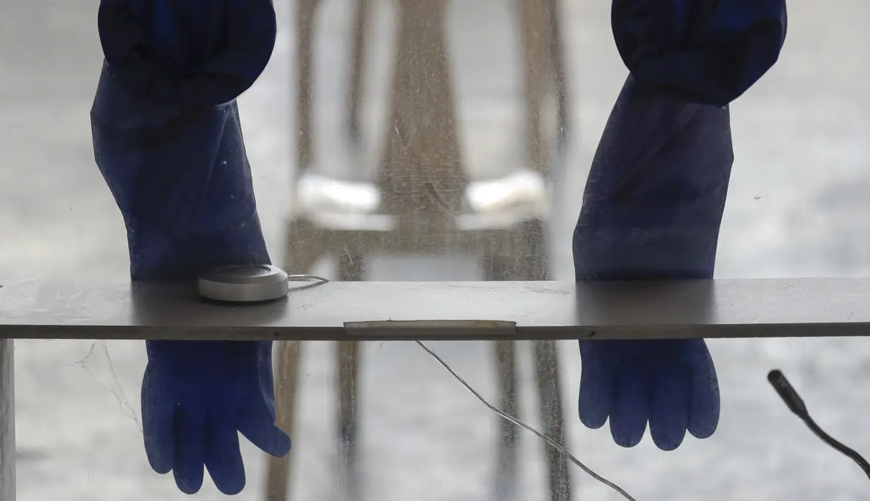 Sarung tangan karet digantung di bilik yang digunakan di lokasi pengujian COVID-19 untuk mengekang penyebaran virus corona di kota Quezon, Filipina, Kamis (29/4/2021). Filipina memperpanjang lockdown selama dua bulan. (AP Photo/Aaron Favila)