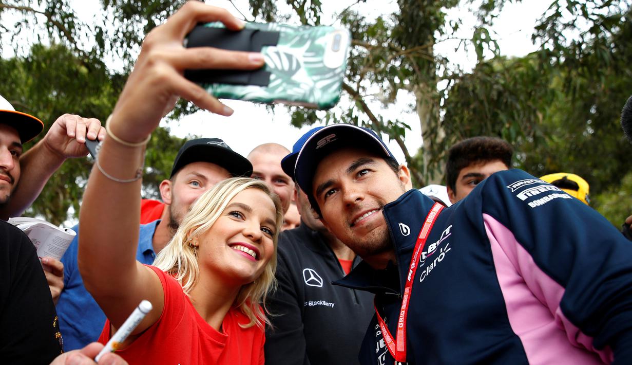 Pembalap F1 Racing Point, Sergio Perez berselfie dengan penggemarnya saat tiba di Sirkuit Melbourne Grand Prix di Melbourne, Jumat (15/3). Seri GP Australia akan menjadi pembuka ajang Formula 1 (F1) musim 2019. (Reuters/Edgar Su)
