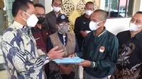 Kepala Dinas Pendidikan Garut Ade Manadin dan tersangka Munir, tersangka kasus pembakaran SMPN 1 Cikelet menyatakan damai, sebelum pelaksanaan restorative justice dilakukan di Mapolres Garut. (Liputan6.com/Jayadi Supriadin)