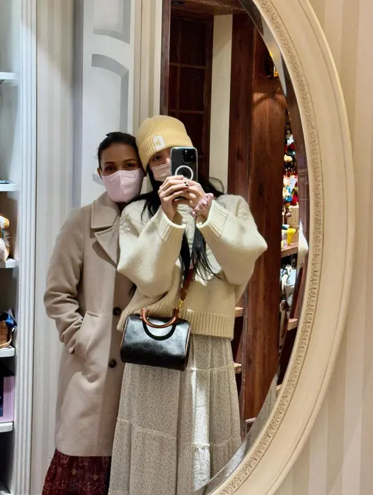 Berfoto selfie dengan Lisa, Chitthip Bruschweiler tampil serasi dengan outfit sang putri. Ia mengenakan dress berwarna merah yang cantik, yang kemudian dilapisinya dengan long coat cokelat. Foto: Instagram.