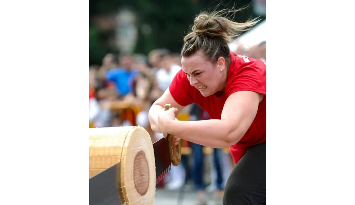 Ekspresi Nerea Sorondo saat memotong batang pohon dengan "tronza" saat kejuaraan olahraga pedesaan di festival San Fermin yang dihelat di Pamplona, Spanyol Utara, (8/7/2014). (AFP PHOTO/Ander Gillenea)