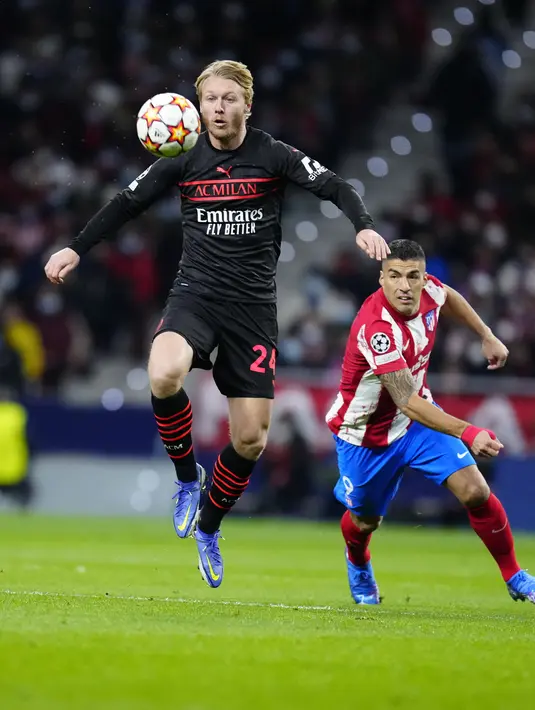 Bek AC Milan Simon Kjaer mengontrol bola saat penyerang Atletico Madrid Luis Suarez mengejarnya pada laga kelima Grup B Liga Champions 2021/2022 di Stadion Wanda Metropolitano, Kamis (25/11/2021) dini hari WIB. AC Milan menaklukkan tuan rumah Atletico Madrid 1-0. (AP Photo/Manu Fernandez)