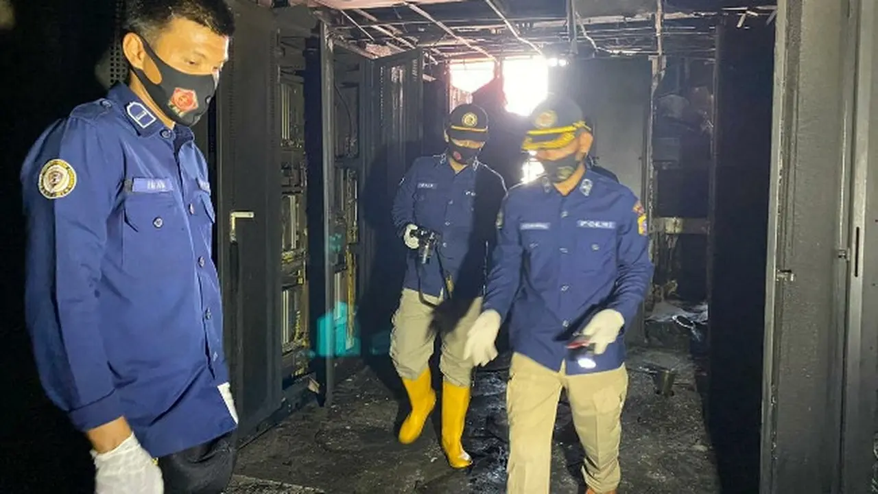 Petugas Laboratorium Feorensik Polda Riau memeriksa ruangan server induk Telkom yang terbakar di Pekanbaru.