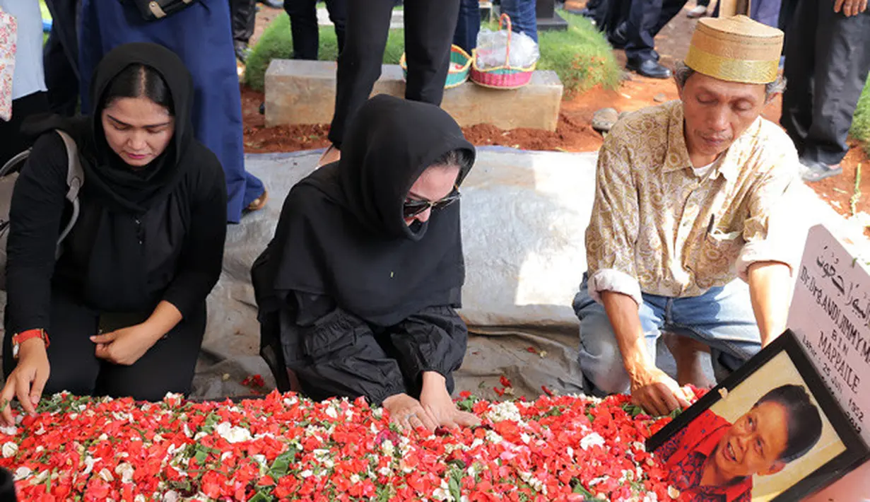 Ketika prosesi pemakaman itu selesai, Kiki yang semula duduk di kursi lalu merapatkan diri berjongkok di sisi pusara sang ayah yang sudah tertimbun tanah dan bertabur bunga. Dengan khusyuk, Kiki memberika doa terbaiknya. (Deki Prayoga/Bintang.com)