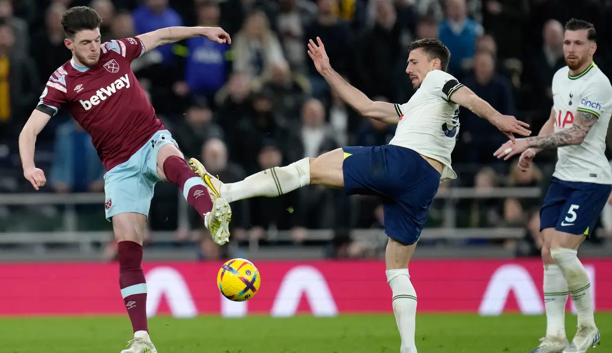<p>Pemain West Ham United Declan Rice (kiri) berebut bola dengan pemain Tottenham Hotspur Clement Lenglet pada pertandingan sepak bola Liga Inggris di Stadion Tottenham Hotspur, London, Inggris, 19 Februari 2023. Tottenham Hotspur mengalahkan West Ham United dengan skor 2-0. (AP Photo/Kirsty Wigglesworth)</p>