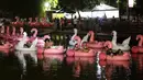 Orang-orang bersantai di atas balon flamingo saat mereka menonton film selama Festival Terapung pertama di Danau Sarah Kubstichek Brasilia, Brasil (30/9/2020). Warga bisa duduk santai di balon karet menonton film dan matahari terbenam di festival ini. (AP Photo/Eraldo Peres)