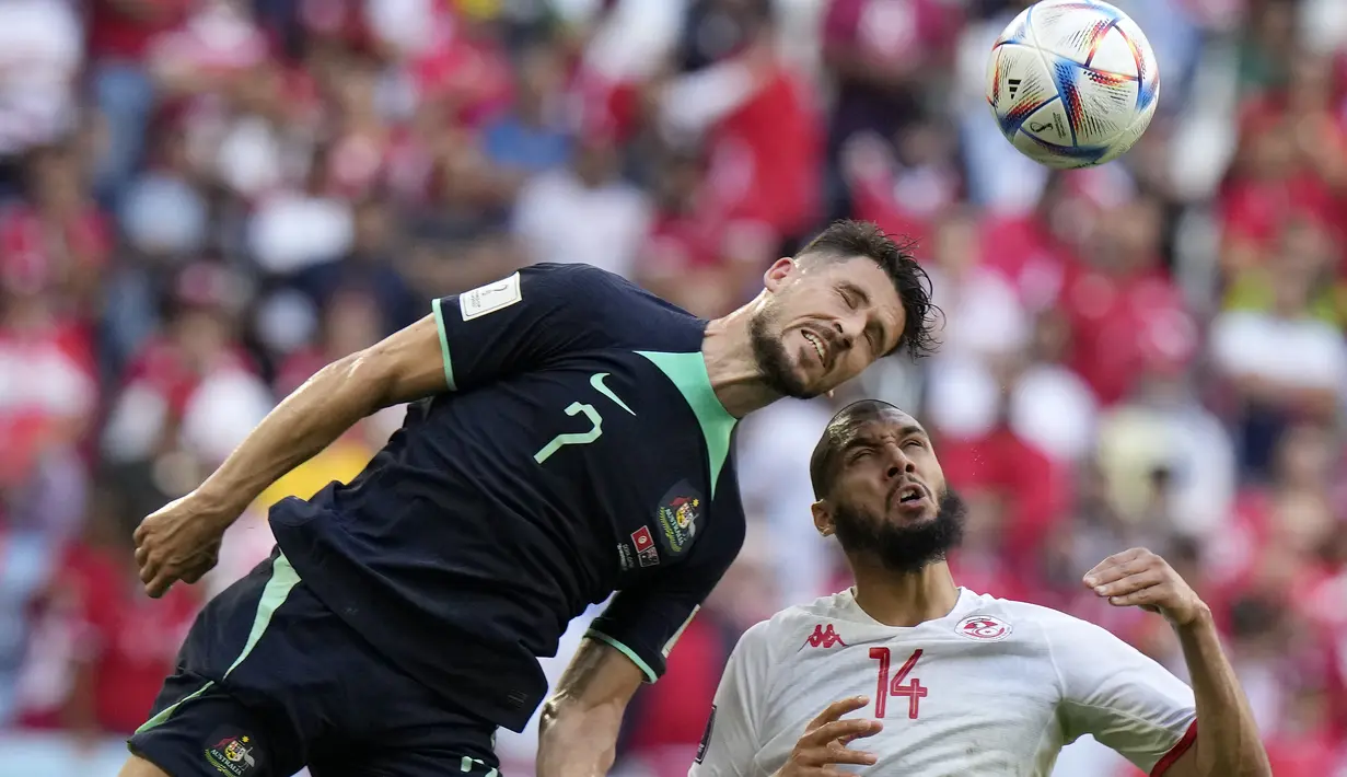 <p>Gelandang Australia, Mathew Leckie berebut bola udara dengan gelandang Tunisia, Aissa Laidouni selama pertandingan grup D Piala Dunia 2022 di Stadion Al Janoub di Al Wakrah, Qatar, Sabtu, 26 November 2022. Sementara Tunisia turun ke posisi ketiga dengan satu poin. (AP Photo/Luca Bruno)</p>