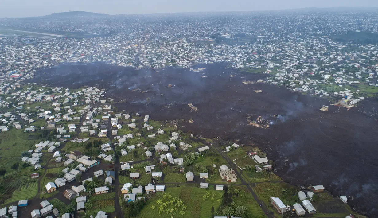 Lava dari letusan Gunung Nyiragongo membelah Buhene di utara Goma, Kongo (24/5/2021). Penduduk kembali ke rumah yang hancur dan mencari orang yang dicintai yang hilang di pinggiran Goma setelah gunung berapi besar itu meletus Sabtu 22 Mei 2021. (AP Photo/Justin Kabumba)