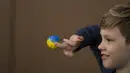 <p>Pengungsi anak-anak Ukraina memegang telur Paskah pada Kamis Putih di sebuah pusat pengungsi di Bucharest, Rumania, 21 April 2022. Orang Rumania yang mayoritas jemaat Ortodoks merayakan Minggu Paskah pada 24 April. (AP Photo/Andreea Alexandru)</p>