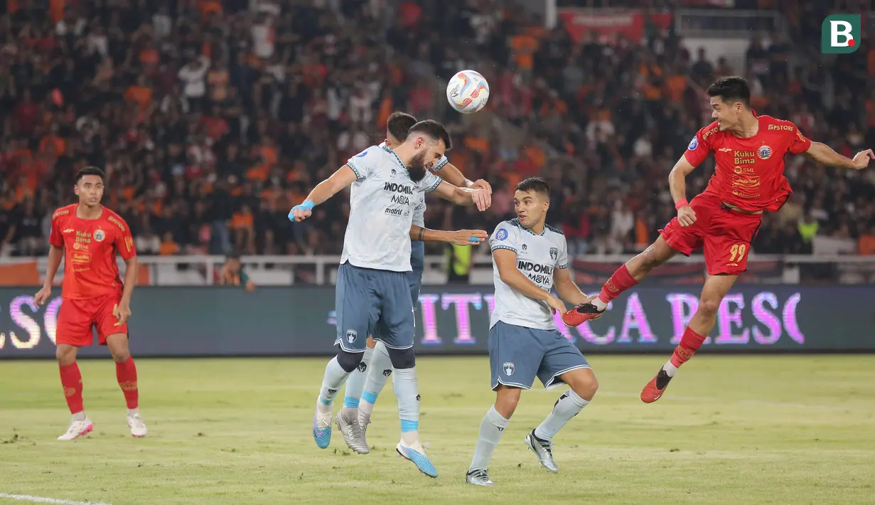 Pemain Persija Jakarta, Aji Kusuma (kanan), menyundul bola ke gawang Persita Tangerang dalam pertandingan pekan ke-21 BRI Liga 1 2023/2024 yang berlangsung di Stadion Utama Gelora Bung Karno, Jakarta, Minggu (3/12/2023) malam WIB. (Bola.com/M Iqbal Ichsan)
