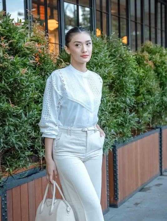 Ide outfit untuk ngantor yang chic ala Anissa Aziza. Ia memadukan atasan blouse putih dipady celana panjang, belt kecil, dan menenteng tas tangan yang semuanya juga berwarna putih. [Foto: Instagram/anissaaziza]