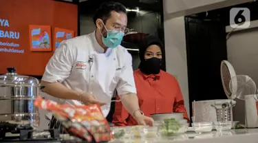 Chef Norman bersama Vokalis band KotaK, Tantri saat membuat hidangan bernutrisi menggunakan bahan-bahan dari daftar "50 Pangan untuk Masa Depan” pada peluncuran Royco Kaldu Ayam dan Sapi di Jakarta, Selasa (26/01/2021). (Liputan6.com/Pool)