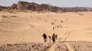 Para wisatawan berjalan melalui daerah Wadi Hudra dekat Ras Ghazala, Sinai Selatan, Mesir, (20/11). Kunjungan ini diikuti oleh 100 orang yang melakukan perjalanan hingga 25 km   . (REUTERS/Asmaa Waguih)
