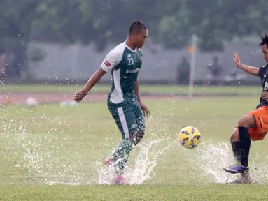 Pemain PS TNi, Wawan Febriyanto (kiri) berebut bola dengan pemain Villa 2000 pada laga uji coba di Lapangan Mako Kostrad, Cilodong, Depok, Rabu (13/4/2016). (Bola.com/Nicklas Hanoatubun)