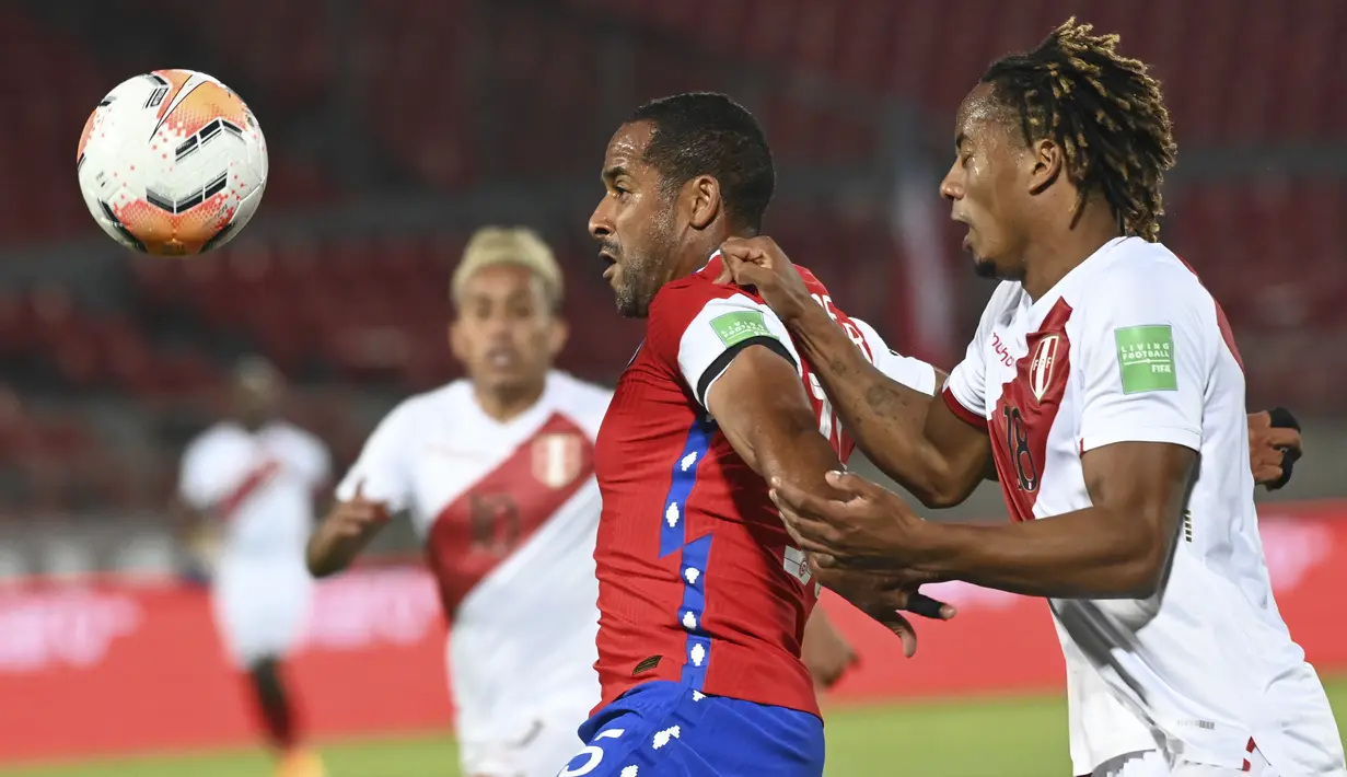 Bek Chile, Jean Beausejour dan gelandang Peru, André Carrillo berebut bola dalam laga Kualifikasi Piala Dunia 2022 zona Conmebol di Estadio Nacional, Santiago, Jumat (13/11/2020). Chile mengalahkan Peru 2-0 berkat gol yang diborong Arturo Vidal. (Martin Bernetti, Pool via AP)
