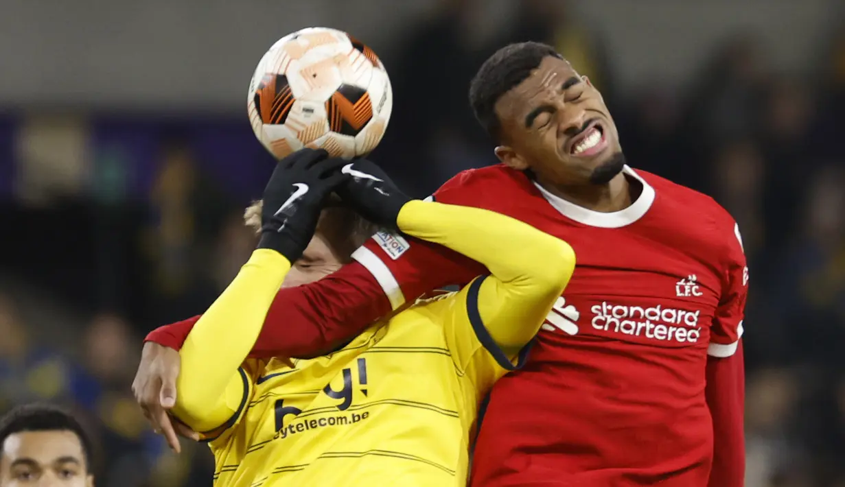 Pemain Union Saint-Gilloise, Dennis Eckert  (kiri), berebut bola di udara dengan pemain Liverpool, Ryan Gravenberch, dalam laga terakhir Grup E Liga Europa 2023/2024 yang berlangsung di Lotto Park, Brussels, Jumat (15/12/2023) dini hari WIB. (AP Photo/Geert Vanden Wijngaert)
