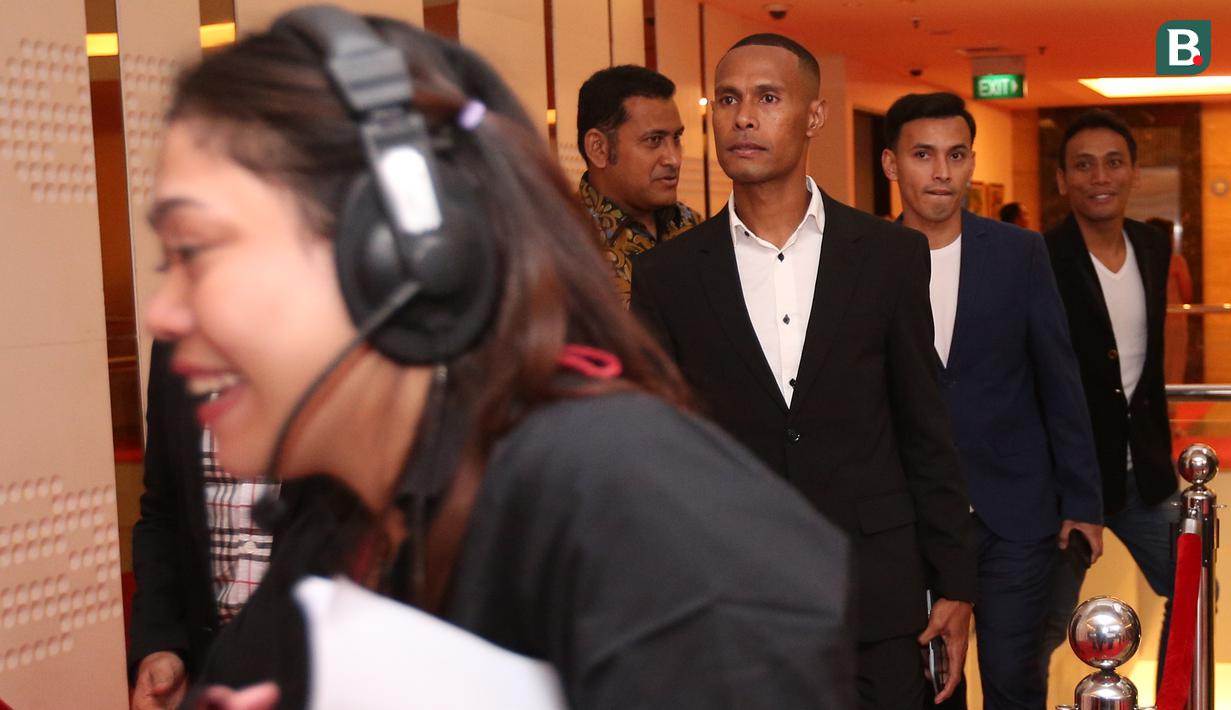 Mantan pemain Persipura, Ruben Karel Sanadi (tengah kiri) dan mantan pemain Sriwijaya FC, Rifky Alhabsyi (tengah kanan) berjalan di atas karpet merah pada sebuah acara yang berlangsung di Hotel JS Luwansa, Kuningan, Jakarta, Rabu (19/07/2023). Ruben dan Rifky terlihat mengenakan jas berwarna hitam yang dipadukan dengan kemeja putih. (Bola.com/Bagaskara Lazuardi)