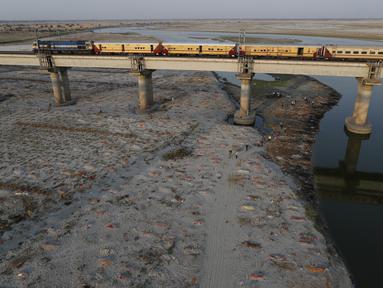 Beberapa jenazah terlihat dimakamkan di kuburan dangkal di tepi sungai Gangga di Prayagraj, 15 Mei 2021. Polisi menjangkau penduduk desa di India utara untuk menyelidiki penemuan jasad di tepi Sungai Gangga yang memicu spekulasi mereka adalah jenazah korban COVID-19. (AP Photo/Rajesh Kumar Singh)