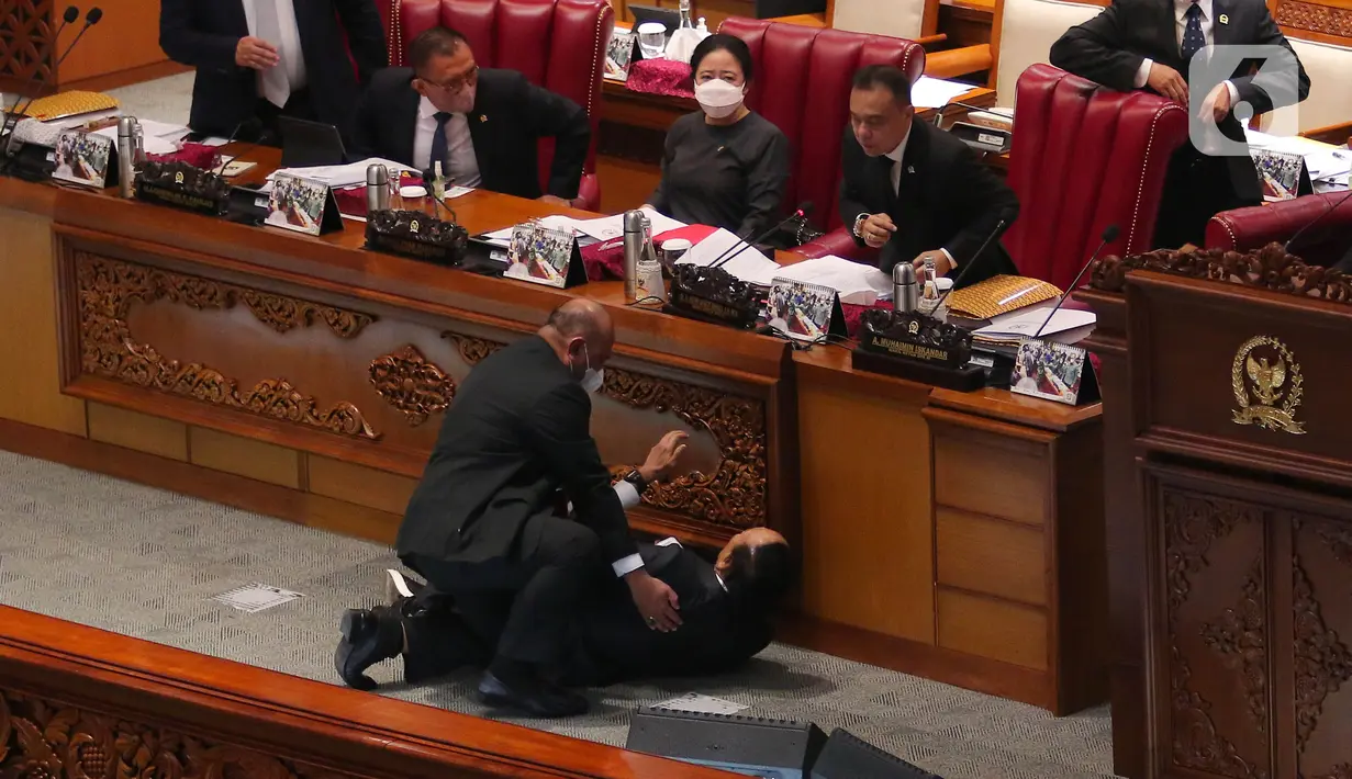 Wakil Ketua Banggar DPR RI Muhidin Muhammad Said terjatuh usai memberikan laporan hasil pembahasan RAPBN 2023 di Rapat Paripurna ke-26 Masa Persidangan V Tahun Sidang 2021-2022 di Gedung nusantara III, Jakarta, Kamis (30/6/2022). Belum diketahui kenapa Wakil Banggar Muhidin sampai terjatuh dan dibawa keruang medis. (Liputan6.com/Angga Yuniar)